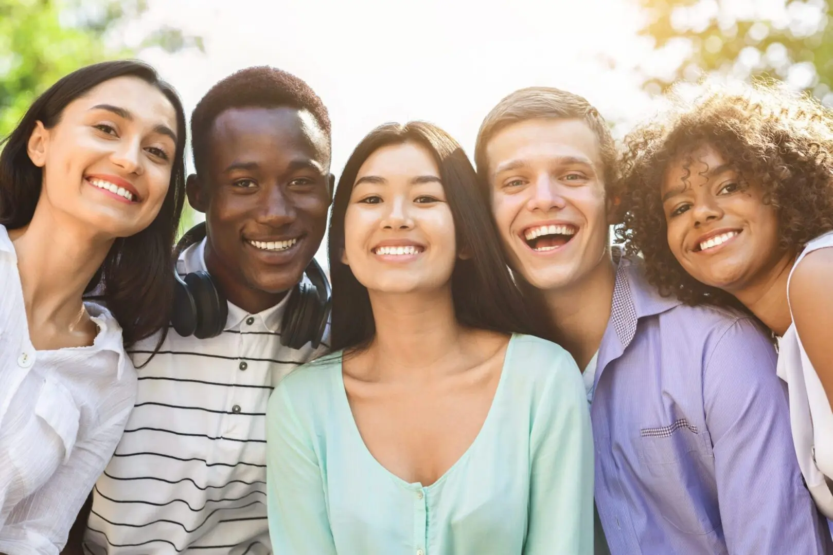 Portrait of cheerful interracial teen friends posing at camera outdoors orthodontist everett