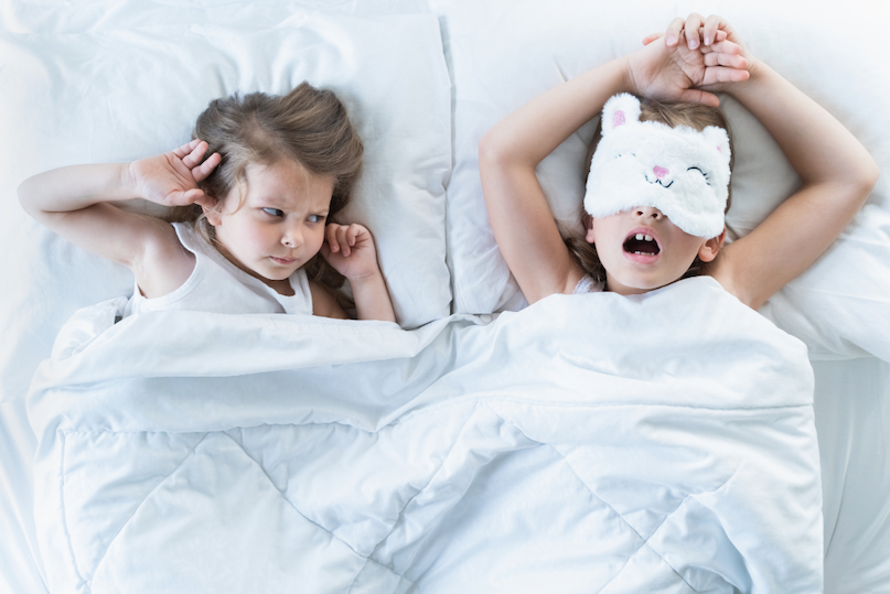 Child snoring with mouth open while frustrated sibling covers ear — childhood snoring and mouth breathing treated by Dr. Sogol, pediatric airway orthodontist in Everett, WA